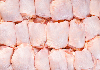 Fresh chicken thigh with skin many pieces close-up. Raw chicken meat.