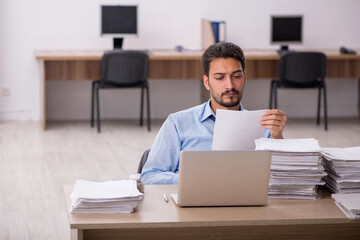 Young male employee and too much work in the office