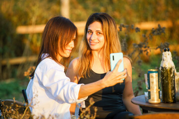 Cheerful happy women friend in nature take selfie by smartphone. Selective focus