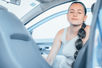 Chica sonriente en el vehículo de copiloto sentada para limpiar el interior del vehículo en el...