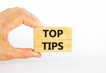 Top tips symbol. Concept words Top tips on wooden blocks on a beautiful white background. Businessman hand. Business and Top tips concept, copy space.