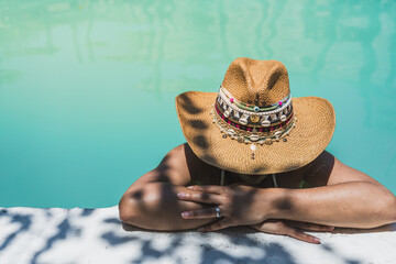 woman with hat in swimming pool