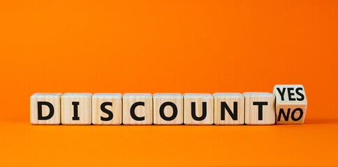 Discount symbol. Turned a wooden cube and changed words 'discount no' to 'discount yes'. Beautiful orange background. Business and discount concept, copy space.