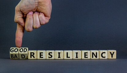 Good or bad resiliency symbol. Businessman turns wooden cubes, changes words bad resiliency to good resiliency. Beautiful grey background, copy space. Business, good or bad resiliency concept.