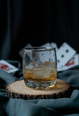 whiskey glass in an elegant setting with poker cards in the background
