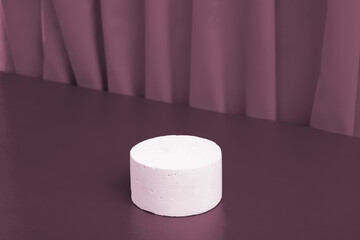 Podiums or pedestal Mock-up for cosmetic production on a dark background with folds of fabric.