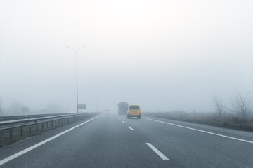 Driver POV on almost empty blue foggy misty rainy highway intercity road with low poor visibility...