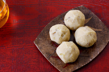 漆塗り板に置かれた皿にのせた栗きんとん