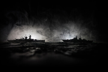 Silhouettes of a crowd standing at blurred military war ship on foggy background. Selective focus....