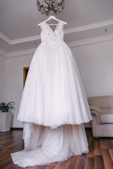 Fototapeta na wymiar beautiful white dress hanging on a hanger. Wedding preparations.