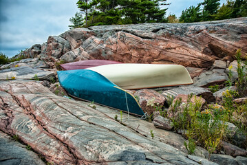 Three canoes resting on an island in Georgian Bay during a canoe trip.