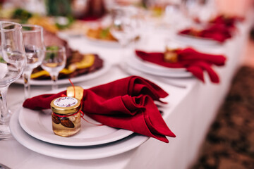 Restaurant Serving Banquet Catering, Wedding Dinner. Lay the table with white plates and red napkins with a small jar of honey and nuts.