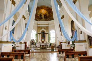mit Fahnen geschmückter kircheninnenraum einer römisch-katholischen kirche in ludza