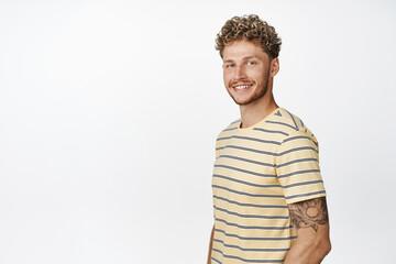 Handsome blond guy smiling happy at camera, looking motivated and hopeful, standing in confident...