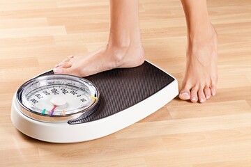 A woman wants to weigh and stands on the scales
