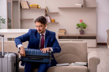 Young businessman preparing for trip at home