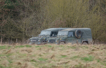 a pair of British army utility medium vehicle Land Rover Defender Wolf on a military exercise...