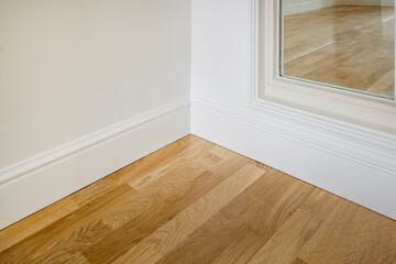 Detail of corner flooring with intricate crown molding and plinth.