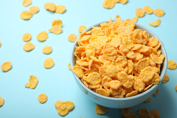Delicious cornflakes in a plate against colored background. 