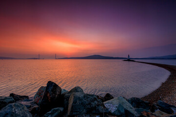 Obraz premium The Tokarevsky lighthouse in Vladivostok stands on a deserted spit. Bright sunrise in the sea capital of the Far East.