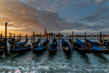 Fototapeta na wymiar Gondolas on the lagoon at Sunrise, Venice, Italy