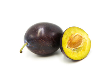 Ripe fresh organic plum whole and half isolated on white background.