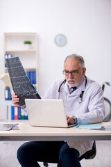 Old male doctor radiologist working at the hospital