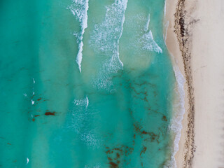 Turquoise sea water and white sandy beach. Light waves. View from above. Aerial photography. Resort place. Rest, relaxation, vacations. Minimalism. Abstraction. there are no people in the photo.
