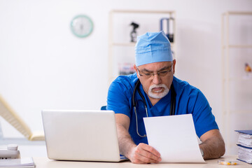 Old male doctor working in the clinic