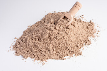Raw flax seeds flour on white background with wooden scoop.