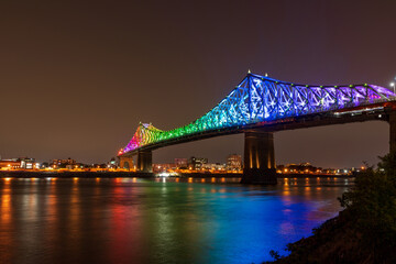 Fototapeta na wymiar Jacques Cartier Bridge in a rainbow lighting at night. Montreal, Quebec, Canada.