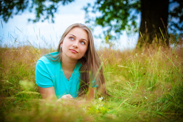 Naklejka na ściany i meble beautiful young brunette woman on the meadow