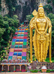 Entrance to the Hindu Temple in Batu Caves,  in Kuala Lumpur, Malaysia. the landscape of the Murugan Sculture and the colourful stairs leading to the temple. 