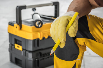 Contractor Worker with Pencil in His Hand and Tools Box