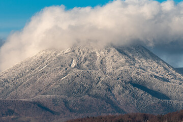 Mountain peak covered with hoarfrost and clouds