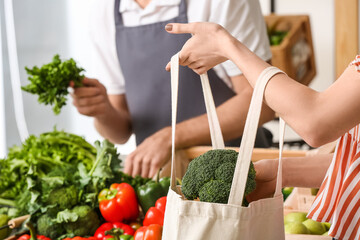 Young woman buying fresh vegetables in market