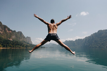 Man jumping with joy by a lake