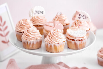 Dessert stand with tasty wedding cupcakes on table