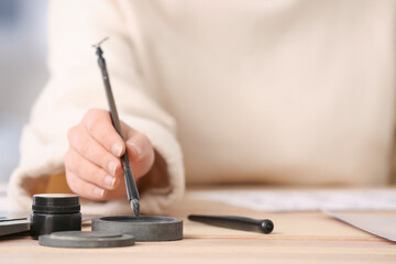 Female Asian calligraphist working in office, closeup