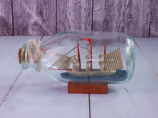 boat in  bottle on wood table for travel or transport concept