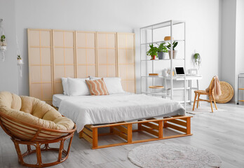 Interior of stylish bedroom with folding screen