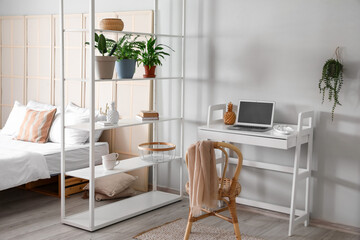 Interior of stylish bedroom with modern workplace