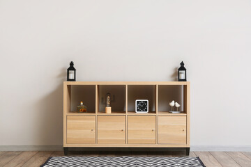 Modern wooden TV stand with decor near light wall