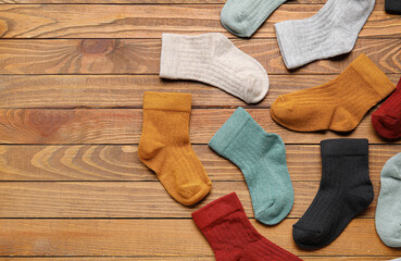 Different baby socks on wooden background, closeup