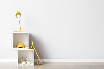 Modern lamp on shelf near white wall