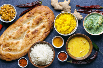 Traditional Indian food with spices on dark background