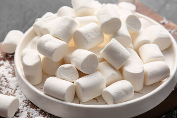 Fototapeta na wymiar Plate with tasty marshmallows on dark background