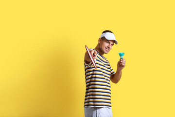 Sporty male badminton player on color background