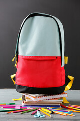 Stylish school backpack and stationery on table