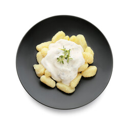 Plate of delicious gnocchi with creamy sauce on white background
